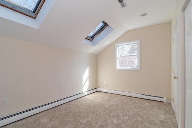 additional living space with lofted ceiling with skylight, carpet, visible vents, and baseboard heating