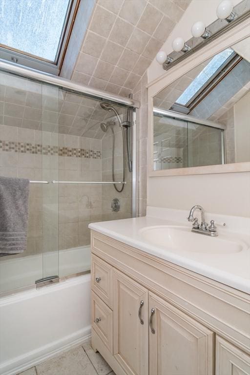 bathroom featuring enclosed tub / shower combo, a skylight, and vanity