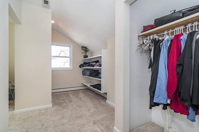 spacious closet with carpet flooring, a baseboard heating unit, visible vents, and vaulted ceiling