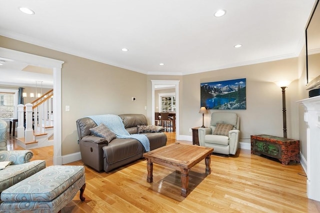 living room featuring stairway, light wood-style flooring, and ornamental molding