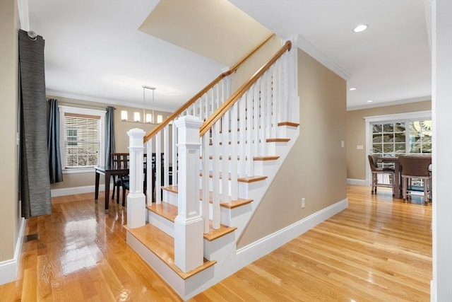 stairs with recessed lighting, crown molding, baseboards, and wood finished floors