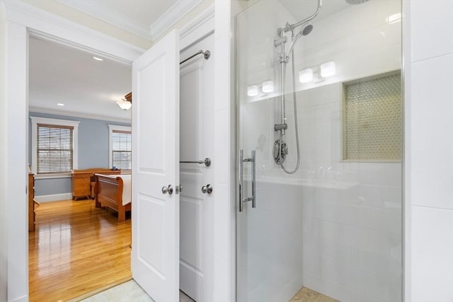 bathroom with wood finished floors, crown molding, and a tile shower