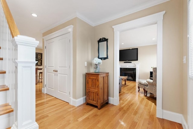 hall featuring stairway, baseboards, crown molding, and light wood-style floors