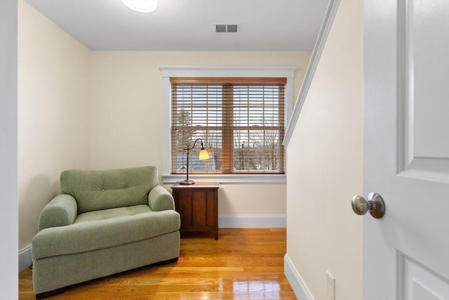 sitting room with visible vents, baseboards, and light wood-style floors