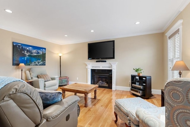 living room featuring baseboards, light wood finished floors, recessed lighting, a tiled fireplace, and crown molding