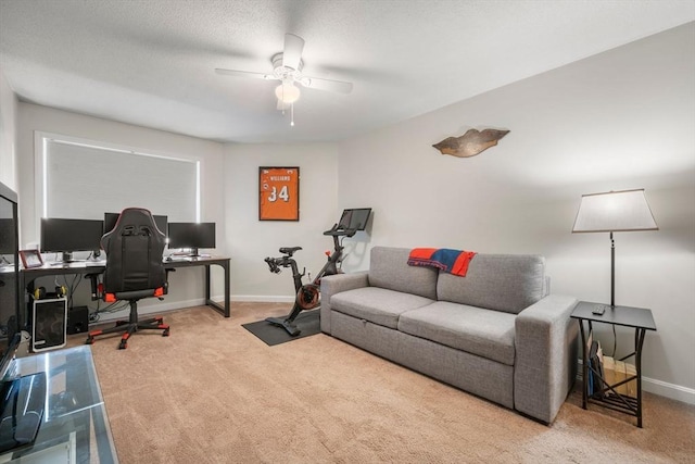 carpeted office space with ceiling fan and baseboards