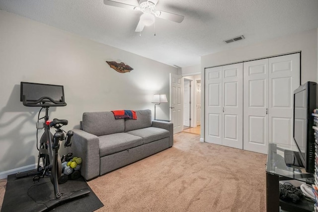 interior space with visible vents, a textured ceiling, a ceiling fan, and carpet flooring