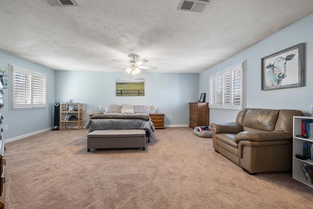 carpeted bedroom featuring a textured ceiling, a ceiling fan, visible vents, and baseboards