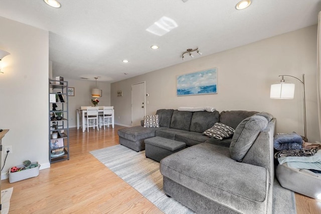 living room with light wood finished floors, baseboards, and recessed lighting