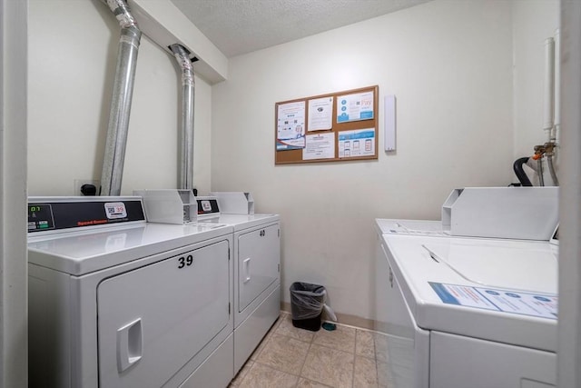 common laundry area featuring washing machine and dryer and a textured ceiling