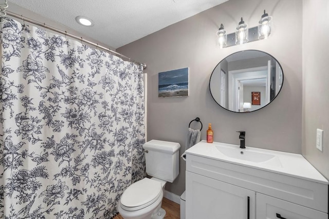 full bathroom with a textured ceiling, a shower with shower curtain, vanity, and toilet