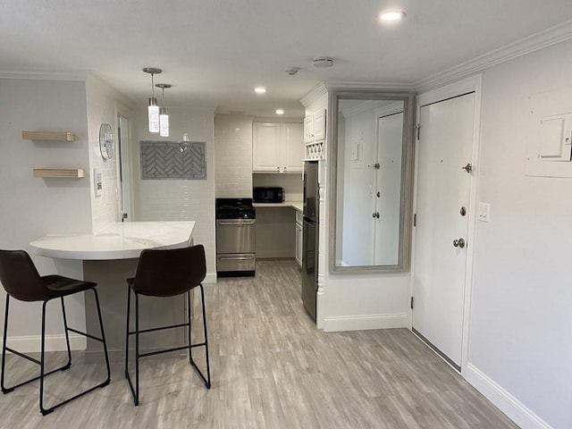 210 Hillside Ave Unit 37, Needham, MA 02494 - kitchen with stainless steel gas range oven, a peninsula, a kitchen bar, crown molding, and light countertops