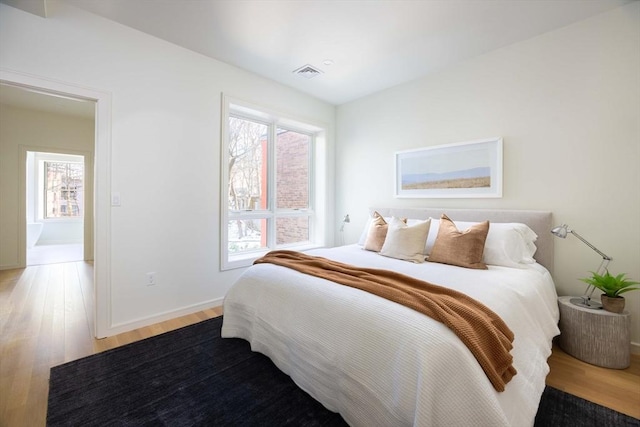 bedroom with multiple windows and wood-type flooring