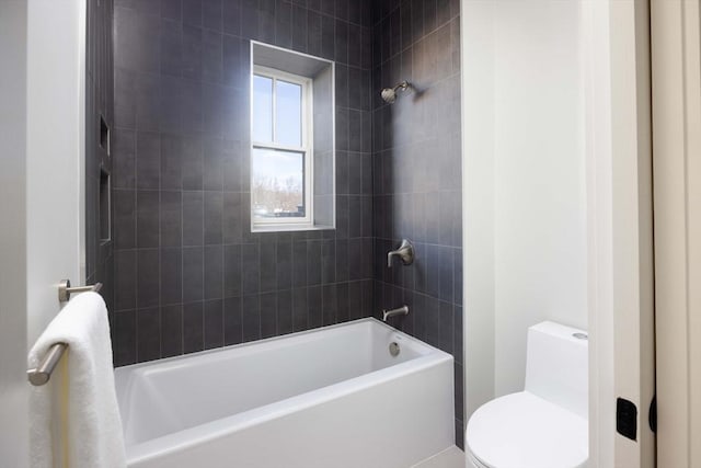 bathroom with toilet and tiled shower / bath