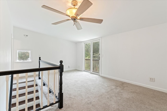 carpeted spare room with ceiling fan and plenty of natural light