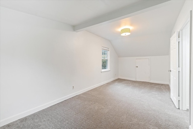 bonus room with light carpet and lofted ceiling with beams