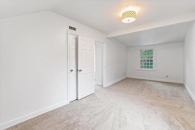 bonus room with lofted ceiling and light carpet