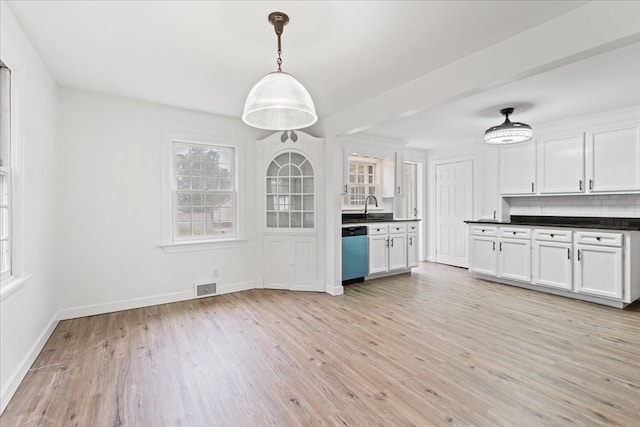 kitchen featuring hanging light fixtures, light hardwood / wood-style floors, stainless steel dishwasher, and white cabinetry