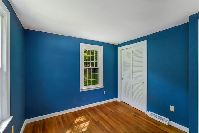 unfurnished bedroom with hardwood / wood-style flooring and a closet