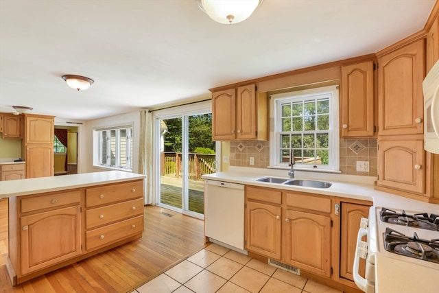 kitchen with light hardwood / wood-style flooring, sink, white appliances, and tasteful backsplash