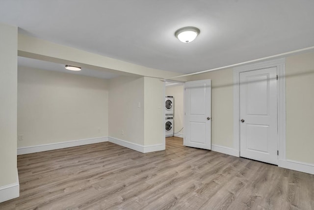 basement featuring stacked washer / dryer and light wood-type flooring