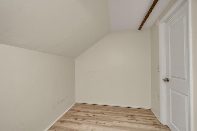 additional living space featuring vaulted ceiling and light wood-type flooring