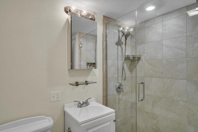 bathroom featuring vanity, toilet, and a shower with shower door