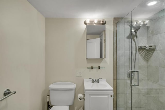 bathroom featuring vanity, toilet, and a shower with shower door