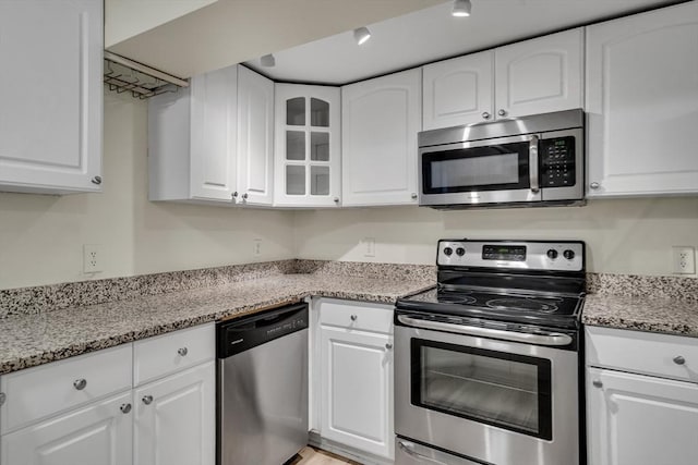 kitchen with white cabinetry, light stone countertops, and stainless steel appliances