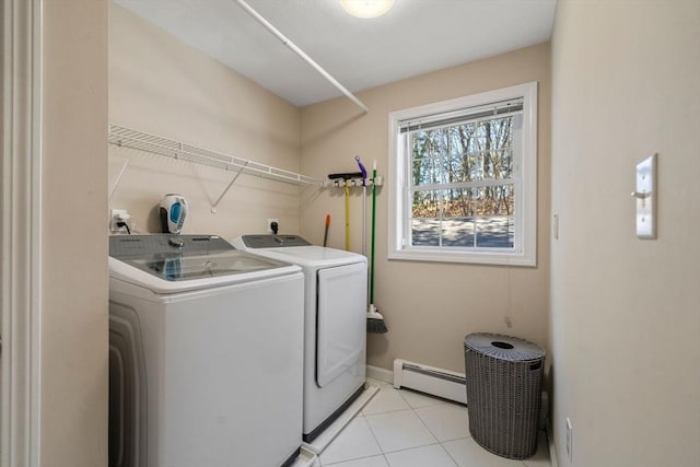 washroom featuring laundry area, light tile patterned floors, baseboards, washing machine and clothes dryer, and a baseboard heating unit