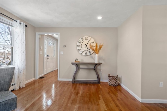 foyer with recessed lighting, visible vents, baseboards, baseboard heating, and light wood-type flooring