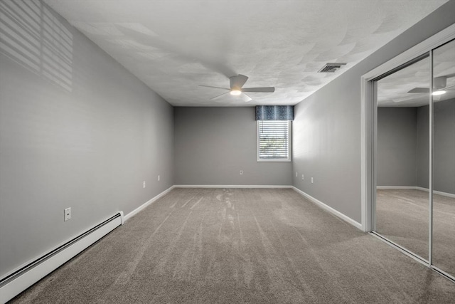 empty room with ceiling fan, carpet floors, visible vents, baseboards, and baseboard heating