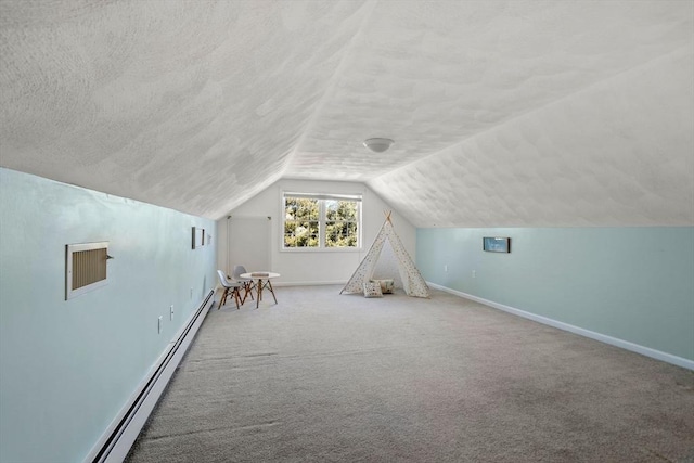 additional living space with carpet floors, lofted ceiling, baseboard heating, a textured ceiling, and baseboards