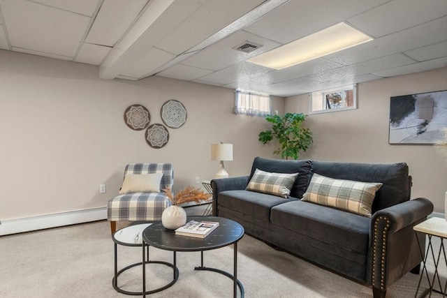 carpeted living room featuring visible vents, a baseboard heating unit, and a drop ceiling