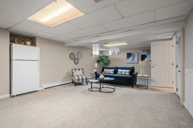 living area with a baseboard heating unit, a drop ceiling, carpet, and baseboards