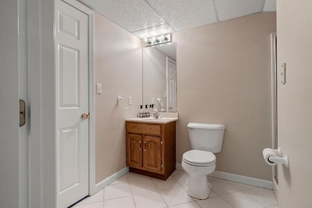 bathroom with toilet, tile patterned floors, baseboards, and vanity