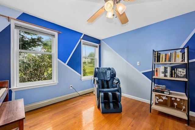 25 Piasta Rd, Dudley, MA 01571 - sitting room with wood finished floors, a ceiling fan, baseboards, and a baseboard radiator