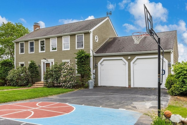 25 Piasta Rd, Dudley, MA 01571 - view of front of house featuring an attached garage, driveway, a chimney, a front yard, and a shingled roof