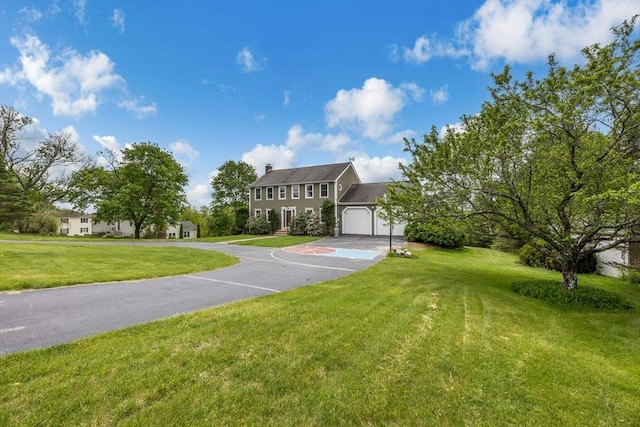 25 Piasta Rd, Dudley, MA 01571 - view of front of house featuring a front yard, a chimney, and a garage