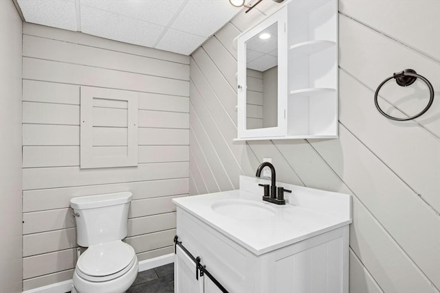 25 Piasta Rd, Dudley, MA 01571 - bathroom with vanity, toilet, a paneled ceiling, and wooden walls