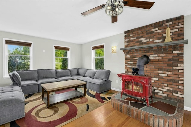 25 Piasta Rd, Dudley, MA 01571 - living area with a wood stove, wood finished floors, a ceiling fan, and baseboards
