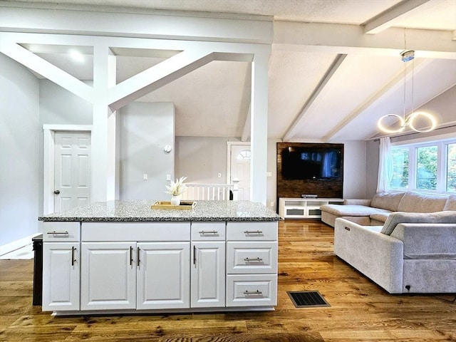 20 Upland Rd, Marlborough, MA 01752 - kitchen featuring open floor plan, white cabinetry, dark wood-style floors, light stone countertops, and a center island