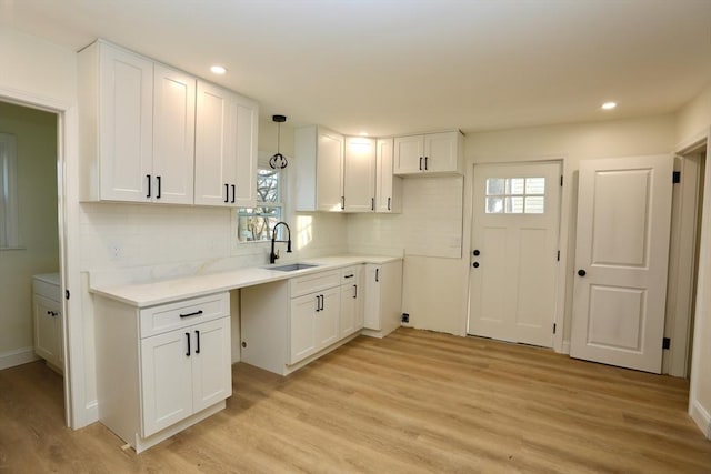 kitchen featuring white cabinetry, sink, and light hardwood / wood-style floors