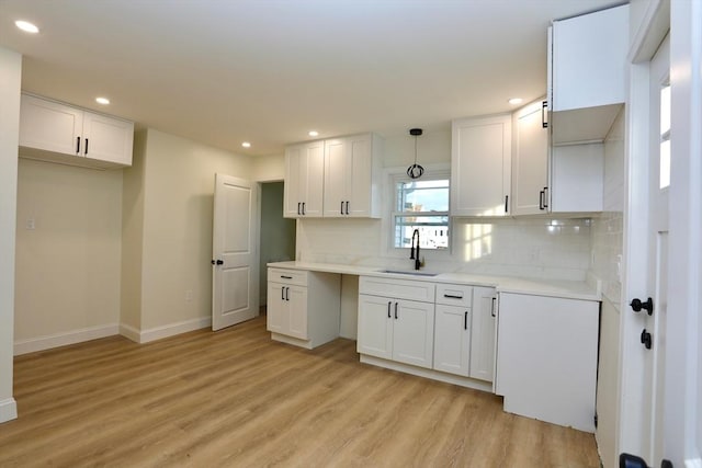 kitchen featuring white cabinetry, sink, and light hardwood / wood-style flooring