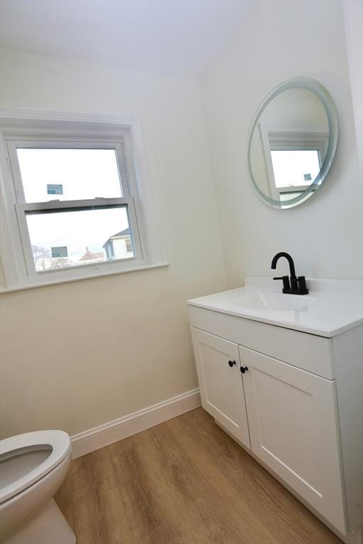 bathroom featuring wood-type flooring, vanity, and toilet