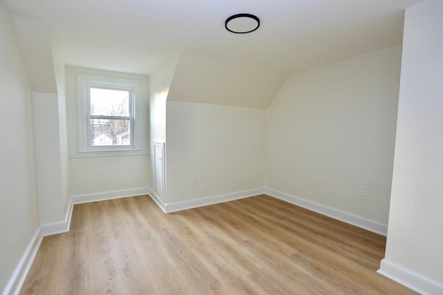 bonus room featuring lofted ceiling and light wood-type flooring