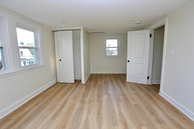 unfurnished bedroom with light wood-type flooring and a closet