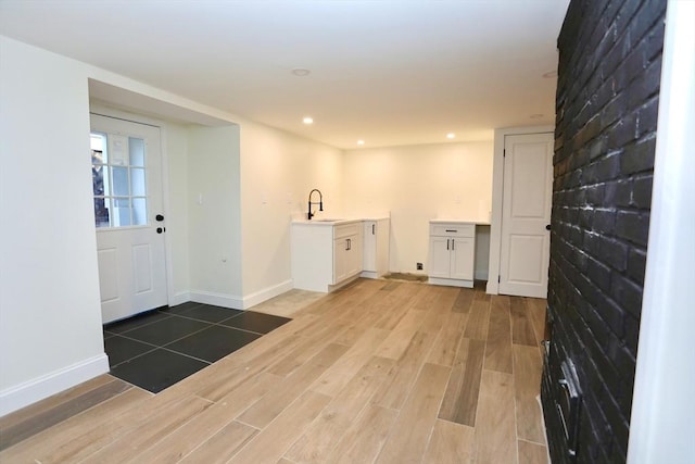 clothes washing area featuring sink and light wood-type flooring