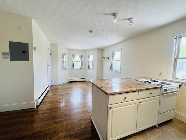 189 Concord Ave Unit 3, Cambridge, MA 02138 - kitchen featuring white range with electric stovetop, a baseboard radiator, electric panel, and healthy amount of natural light