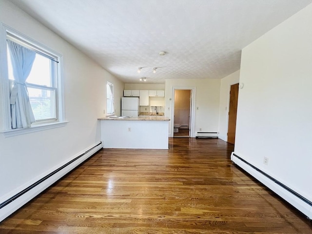 189 Concord Ave Unit 3, Cambridge, MA 02138 - unfurnished living room featuring a baseboard radiator, baseboard heating, and dark wood-style floors